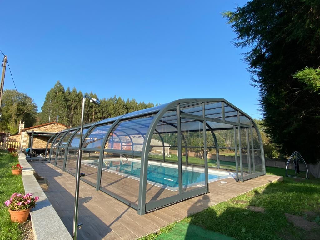 Una gran piscina está cubierta con un techo transparente.