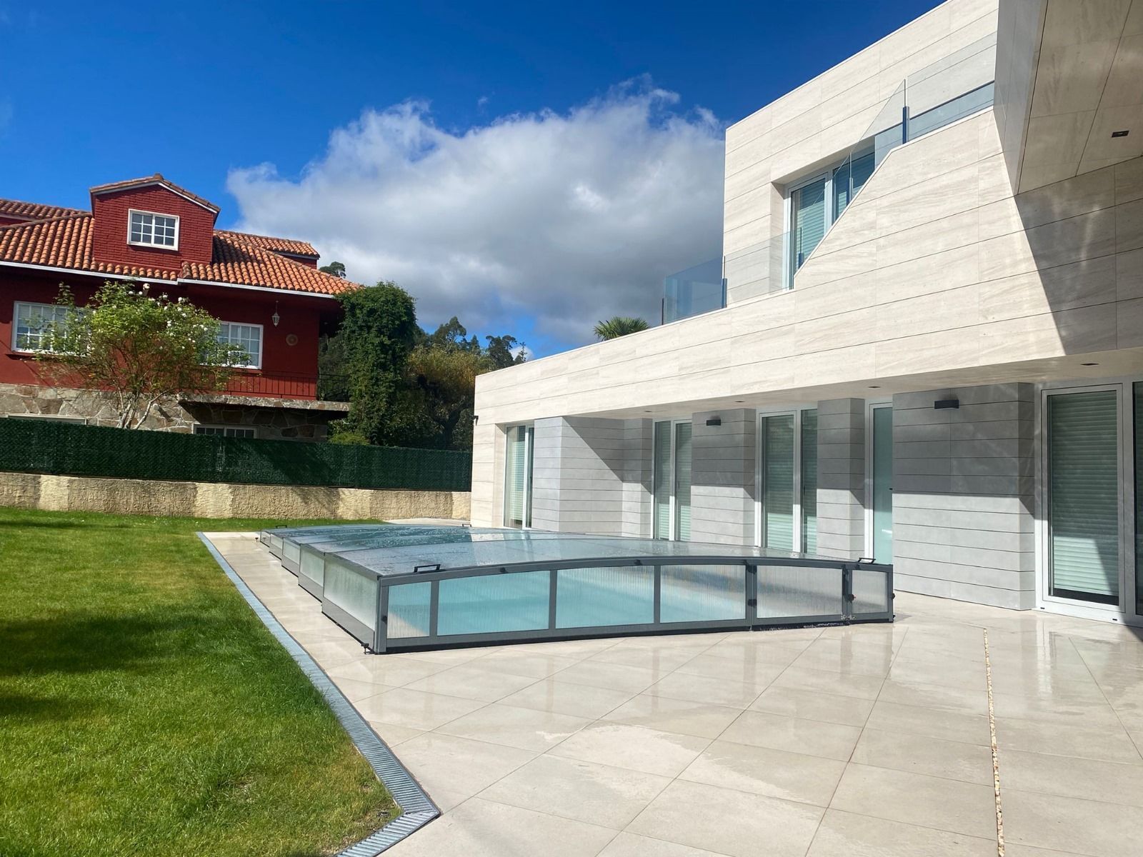 Una casa grande con piscina delante de ella.