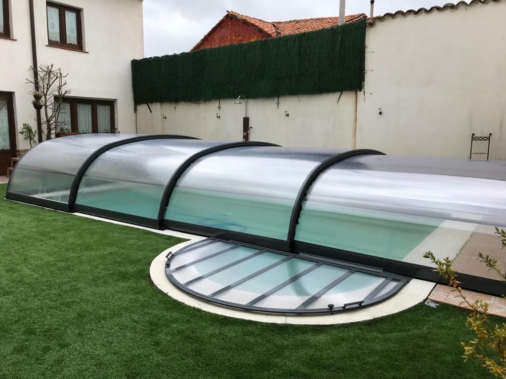 Una piscina con cubierta en un patio trasero.