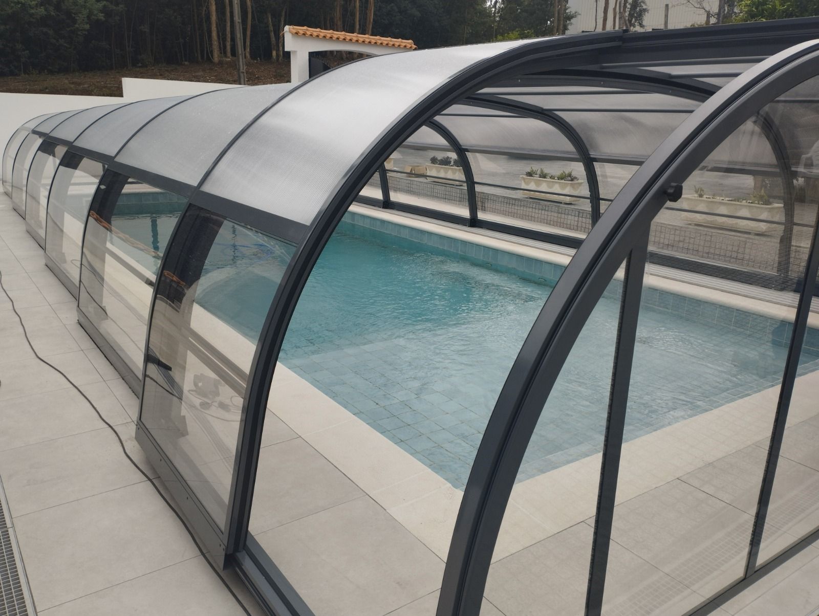Una gran piscina está cubierta por un techo transparente.