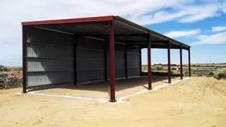 Un balcón con un edificio de ladrillo al fondo.
