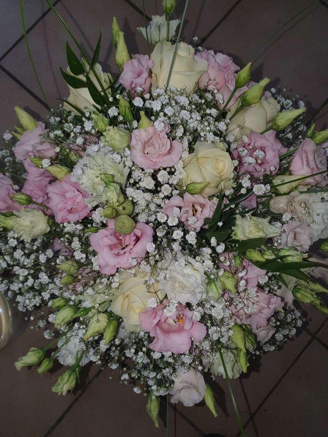 Rosa-weisses Blumenarrangement mit Rosen und Schleierkraut auf dunklem Hintergrund