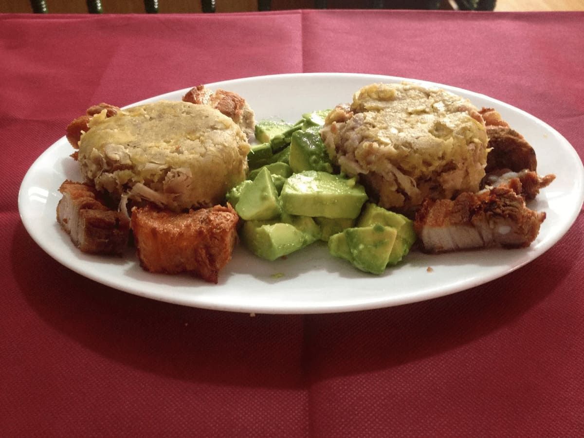 Un plato de comida con carne y aguacate en una mesa.