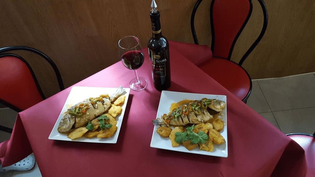 Dos platos de comida y una botella de vino en una mesa.