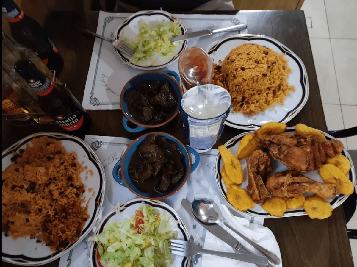 Una mesa cubierta con platos de comida y botellas de refresco.