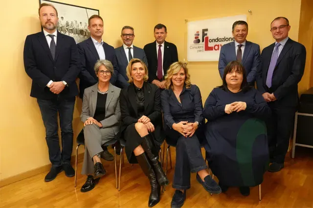Un gruppo di persone posa per una foto in una stanza