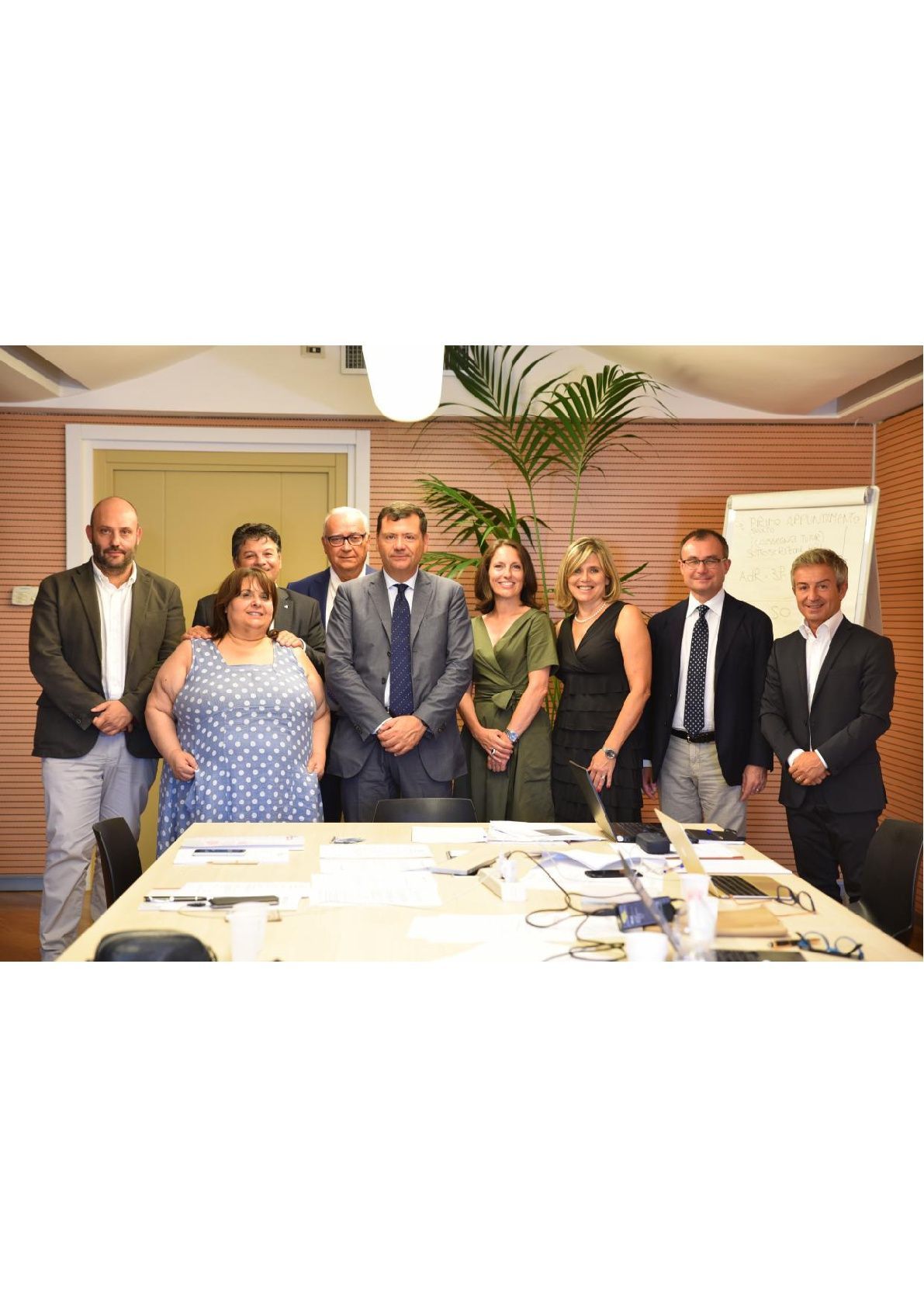 Un gruppo di persone posa per una foto davanti a un tavolo da conferenza.