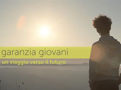 Un uomo è in piedi sulla cima di una collina e guarda il sole.