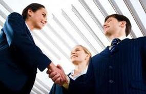 Un gruppo di uomini d'affari si stringono la mano in un ufficio.
