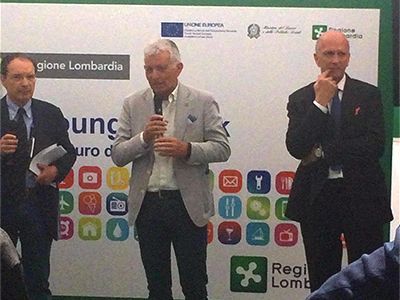 Tre uomini in piedi davanti a un cartello che dice regione lombardia