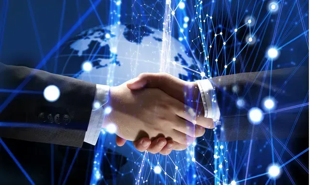 Due uomini d'affari si stringono la mano davanti a un mappamondo.