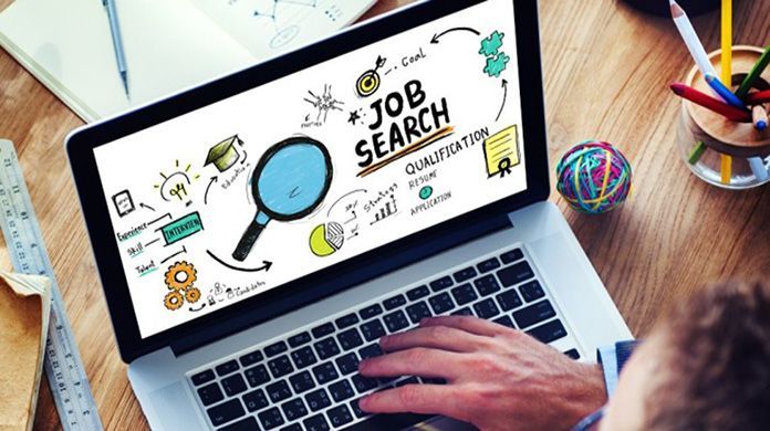 Una persona sta scrivendo su un computer portatile mentre sullo schermo compare una ricerca di lavoro.