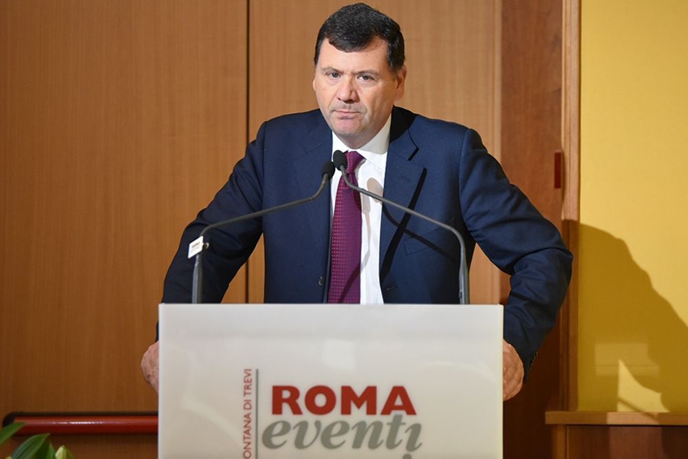 Un uomo sta dietro un podio su cui è scritto