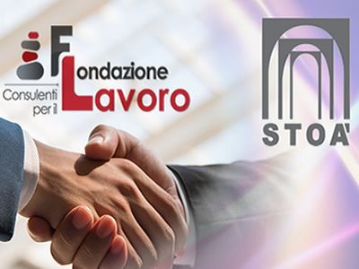 Due persone si stringono la mano davanti a un cartello con la scritta STOA