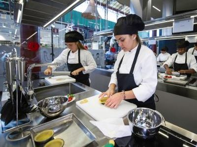 Un gruppo di chef sta preparando il cibo in cucina.