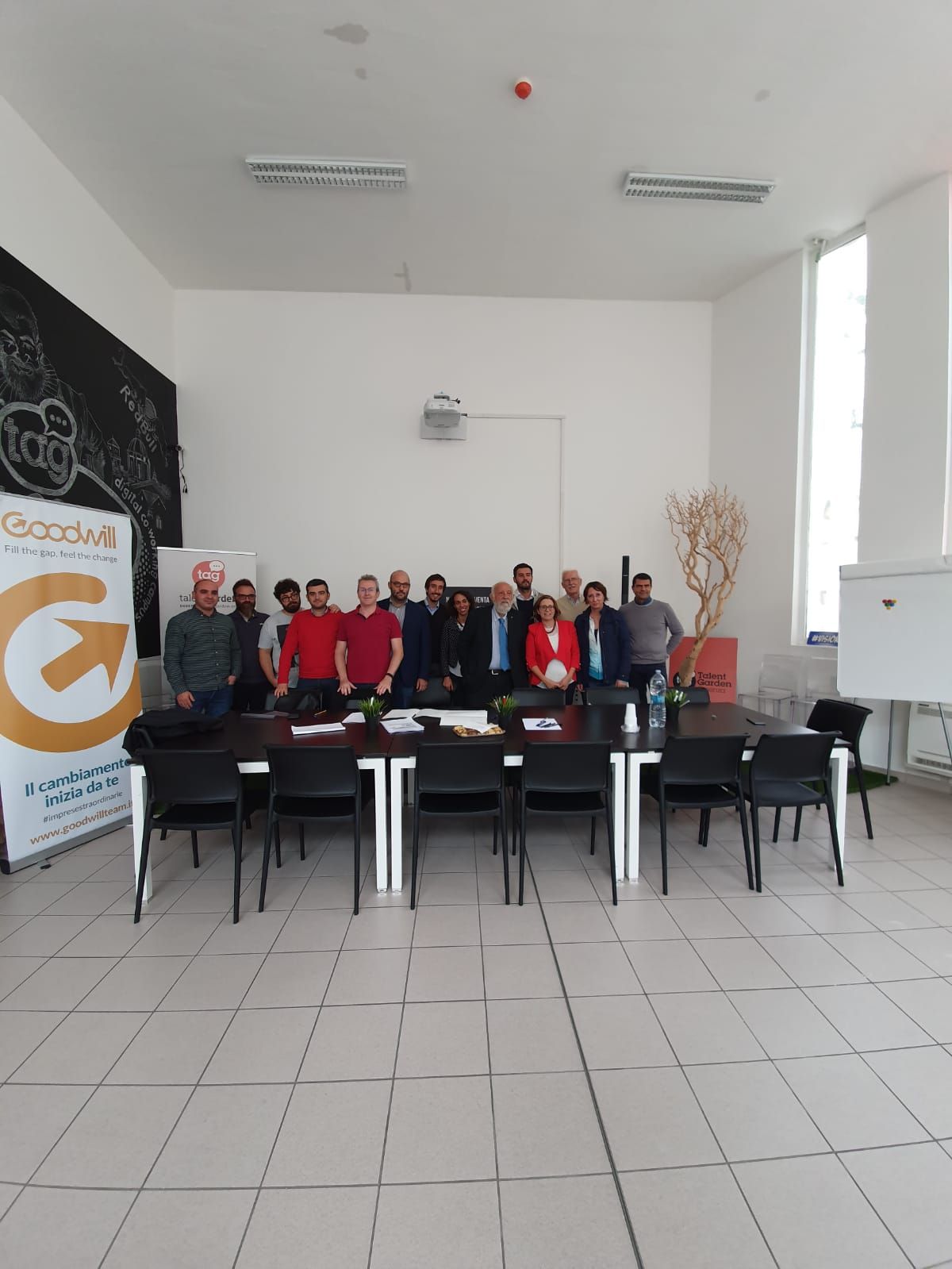 Un gruppo di persone posa per una foto in una sala conferenze.