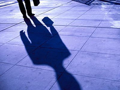 L'ombra di una persona che cammina su un marciapiede