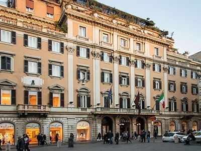 Un grande edificio con molte finestre e persone che camminano davanti ad esso
