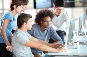 Un gruppo di persone sta guardando lo schermo di un computer.