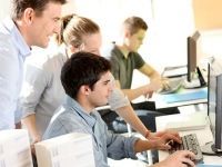 Un gruppo di persone sta guardando lo schermo di un computer.