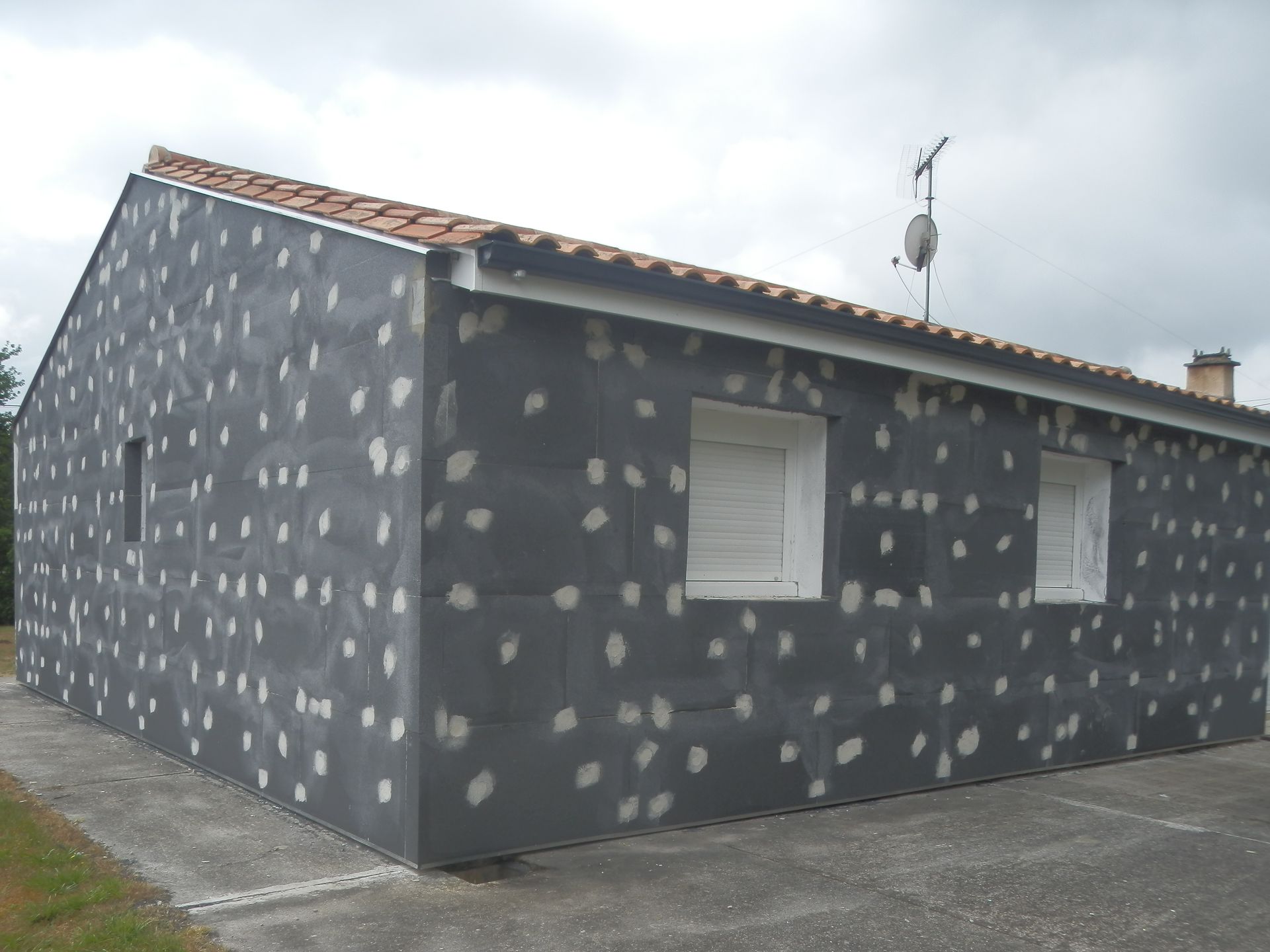 L'extérieur d'une maison est recouvert de panneaux isolants gris.