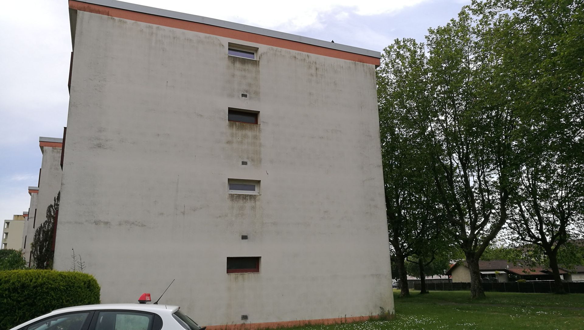 Un mur latéral nu d'un immeuble d'appartements à plusieurs étages, avant ravalement.