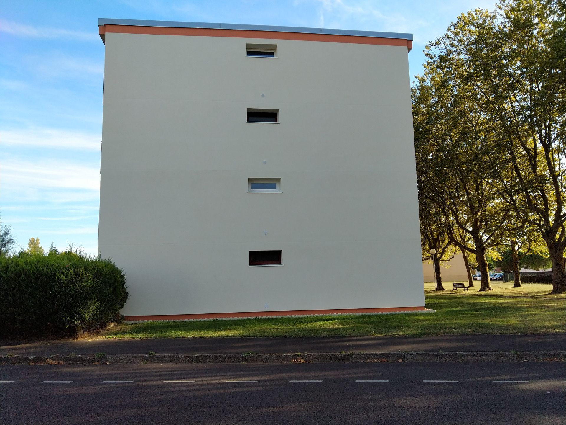 Un mur latéral nu d'un immeuble d'appartements à plusieurs étages, après ravalement.