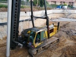 Una excavadora amarilla está parada en el suelo en un sitio de construcción.
