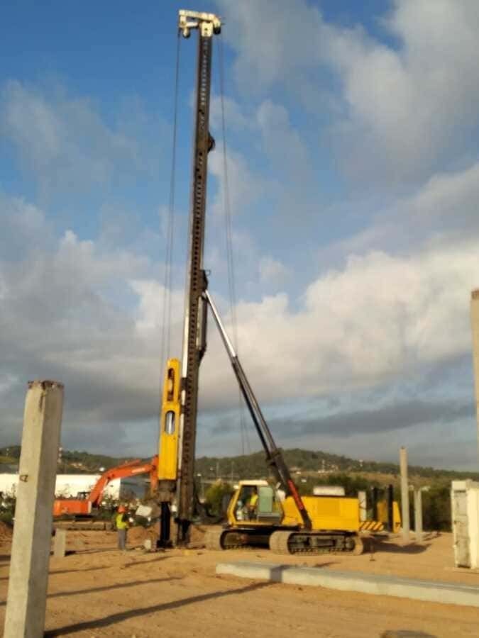 Una obra en construcción con una gran grúa amarilla en primer plano