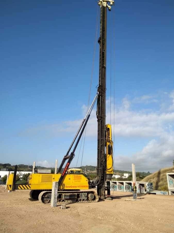 Un gran vehículo de construcción amarillo está estacionado en un campo de tierra.