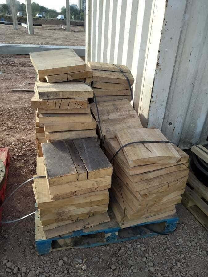 Una pila de madera reposa encima de una paleta de madera.