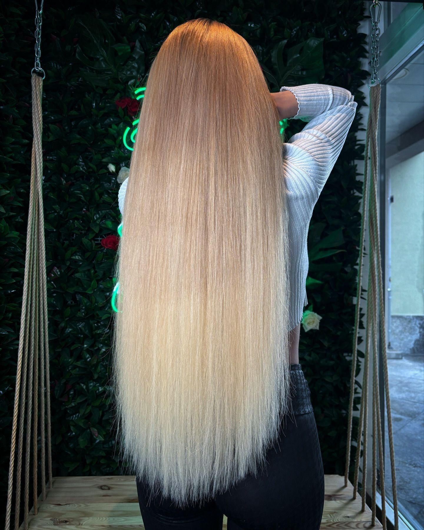 Eine Frau mit sehr langen blonden Haaren steht vor einem Weihnachtsbaum.