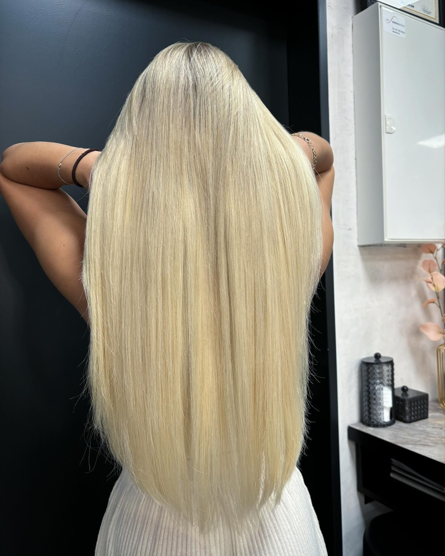 Eine Frau mit sehr langen blonden Haaren steht in einem Raum.