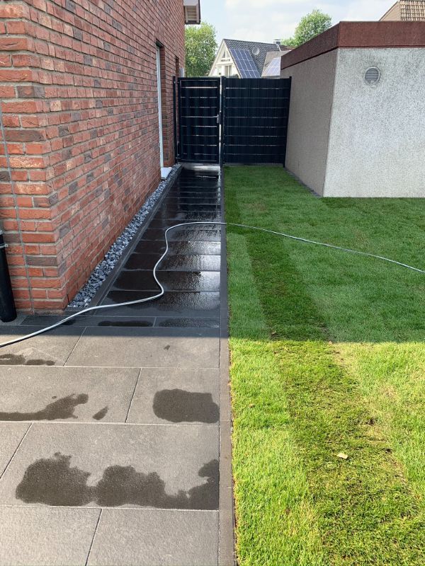 Grüner Rasen an einem Haus mit roten Backsteinen