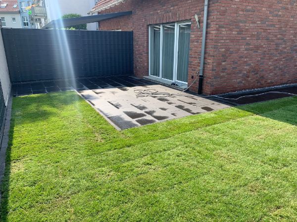 Grüner Rasen an einem Haus mit roten Backsteinen