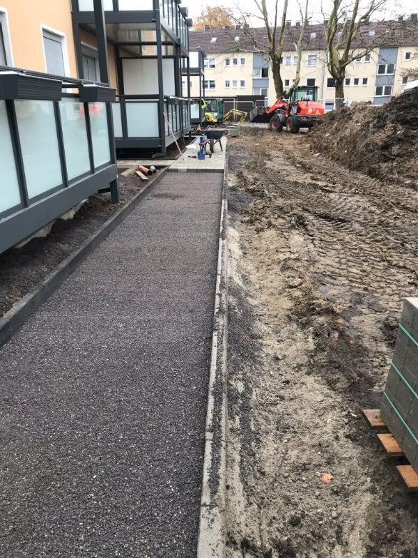 Weg an einem modernen Haus mit Baustelle