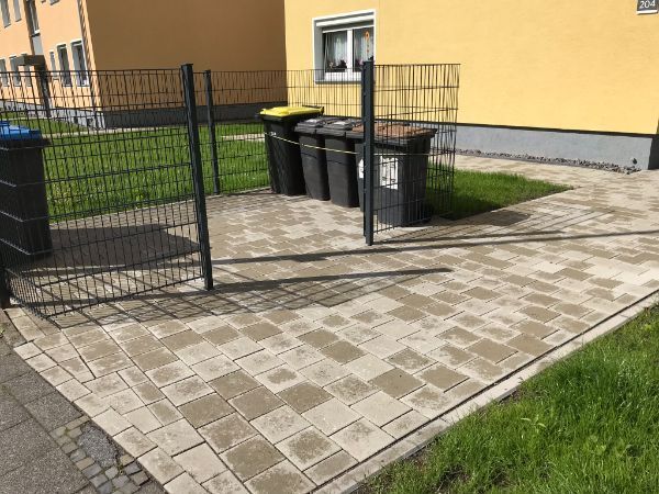 Gepflasterter Weg und Metallzaun