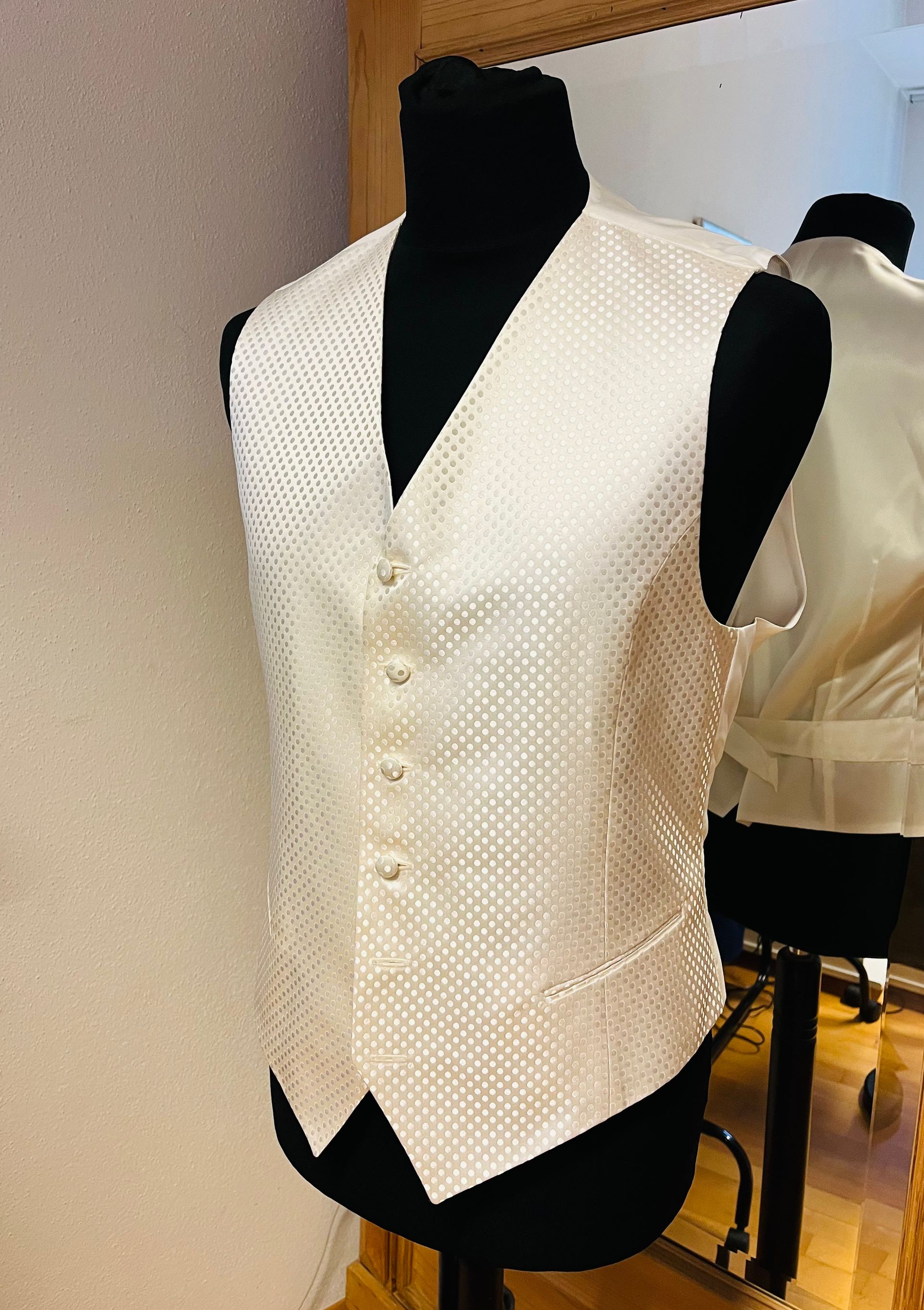 Ein Mann im Anzug und mit Sonnenbrille steht mit den Händen in den Taschen da.