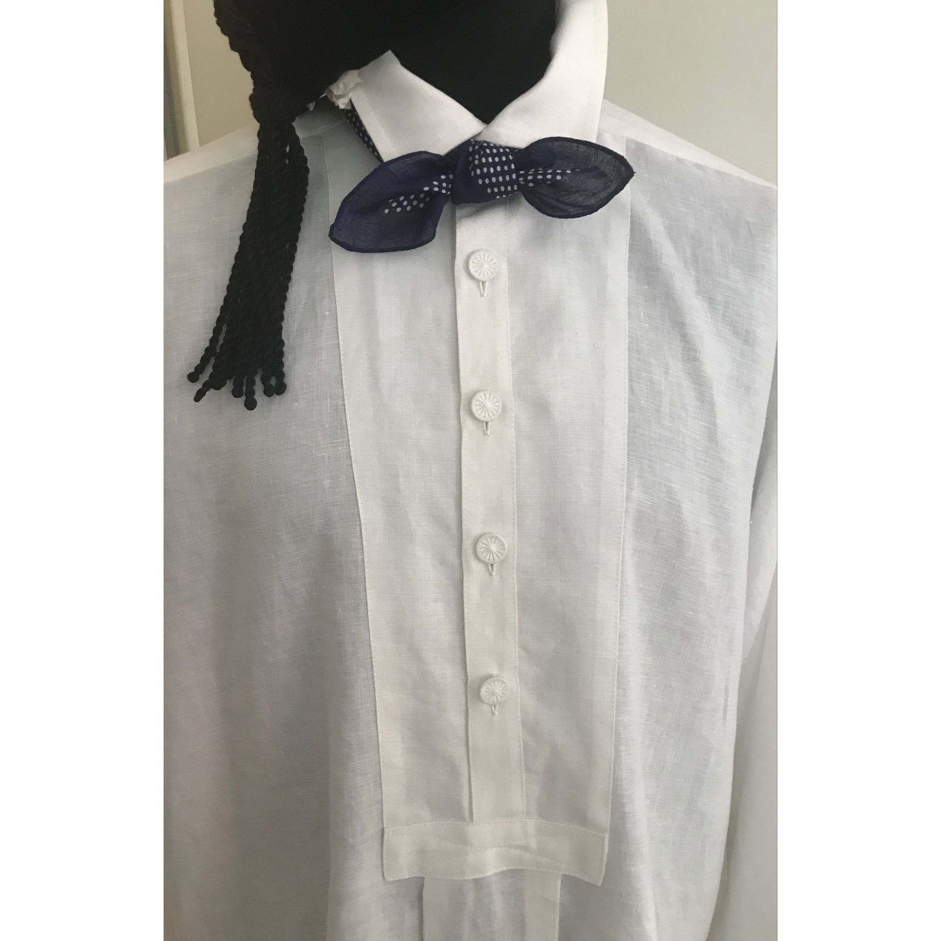 Weißes Hemd mit dunkler Fliege und dekorativer Vorderseite.