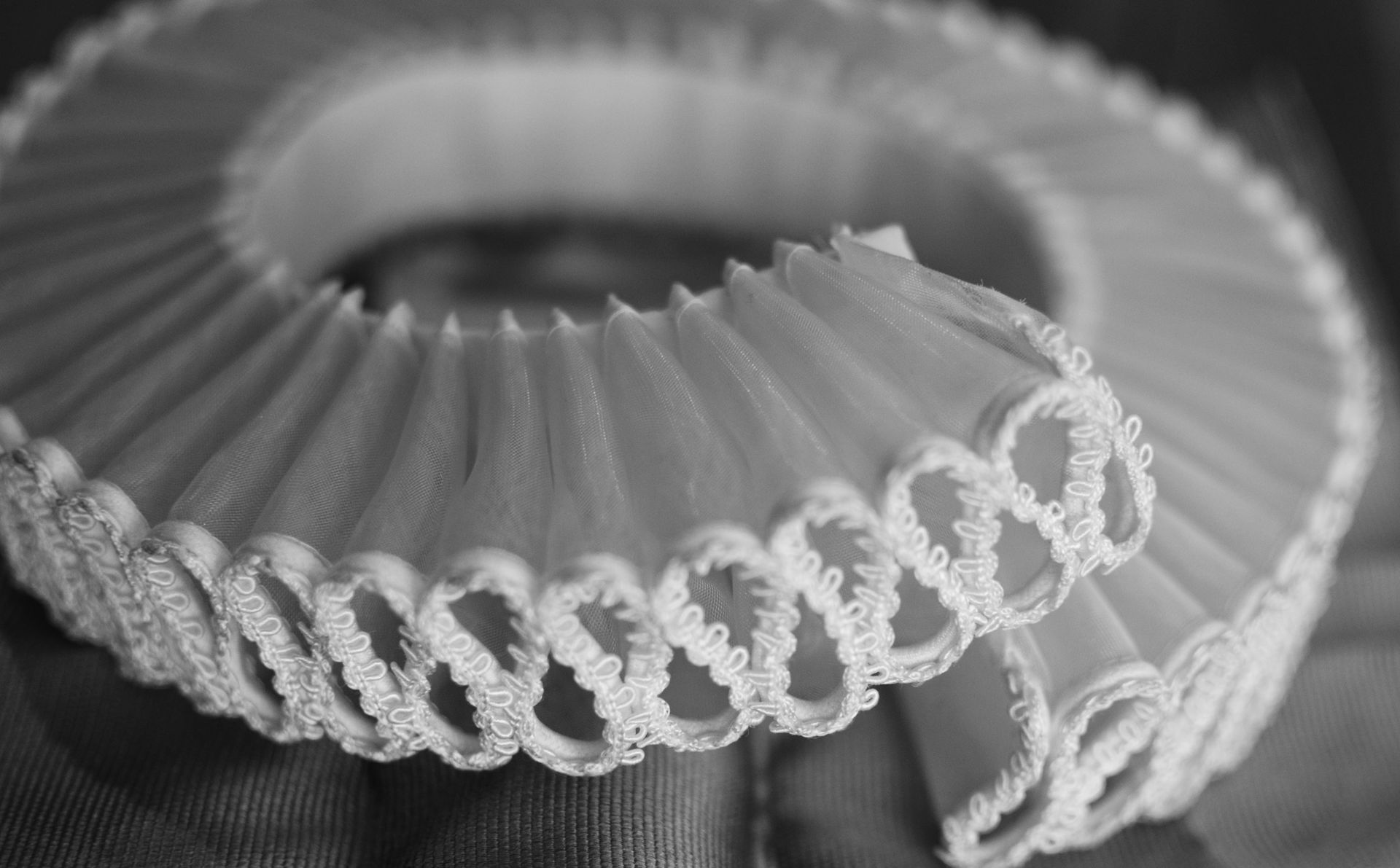 Nahaufnahme eines weißen, gerüschten Kragens im elisabethanischen Stil mit dekorativem, geschlungenem Rand.