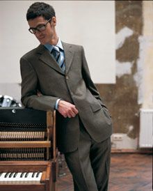 Ein Mann in Anzug und Krawatte richtet sein Jackett