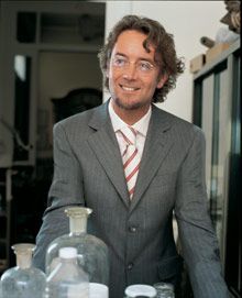 Ein Mann mit Brille und hellbraunem Hemd läuft vor einem weißen Hintergrund.