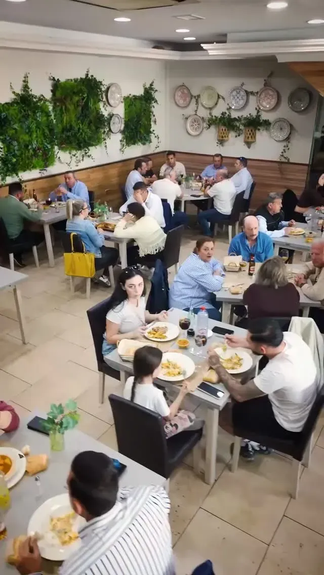 El interior del restaurante, muy bien iluminado, cuenta con mesas cuadradas y sillas de terciopelo en tonos rojos.