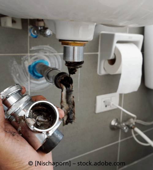 Eine Person hält ein Rohr unter einem Waschbecken in einem Badezimmer, R & I Felber Service GmbH