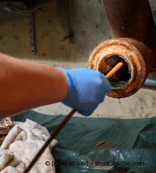 Eine Person mit blauen Handschuhen reinigt ein Rohr, R & I Felber Service GmbH