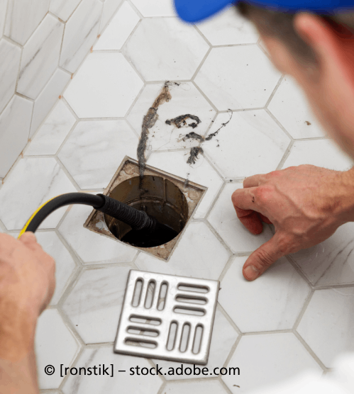 Ein Mann repariert einen Abfluss in einem Badezimmer, R & I Felber Service GmbH