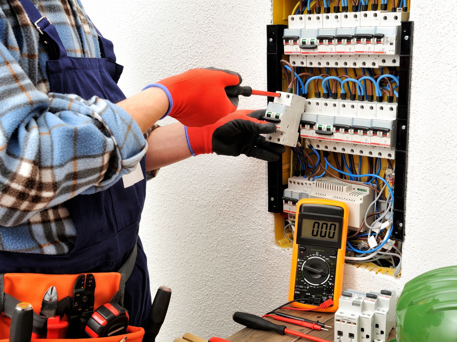Un électricien teste un tableau de disjoncteurs avec un multimètre