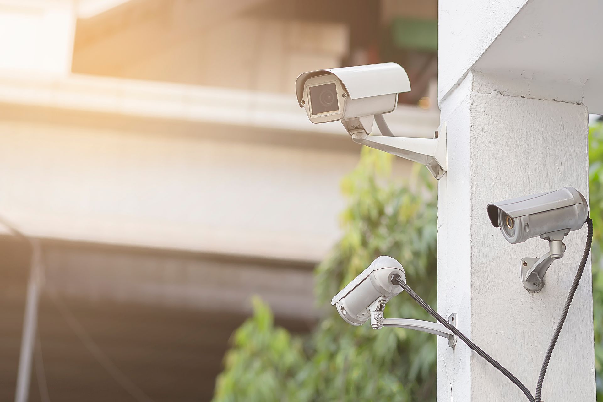 Des caméras de sécurité sont installées à l'angle d'un bâtiment et surveillent un espace extérieur.
