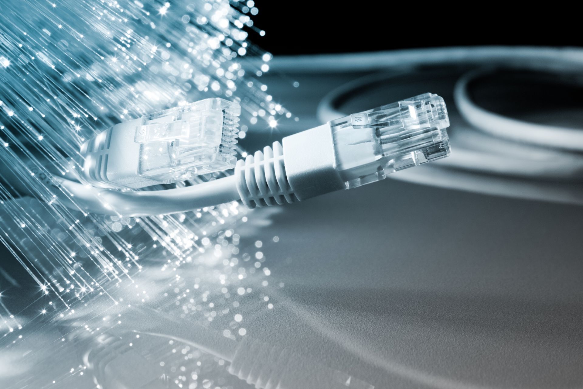Des fibres optiques lumineuses et une prise Ethernet transparente sur une surface sombre
