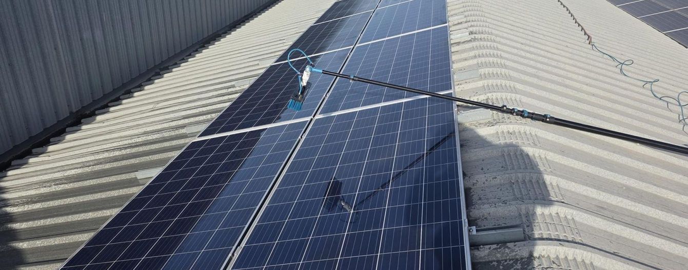 Estación de carga de vehículos eléctricos con energía solar con automóviles estacionados y cargándose en un día soleado.